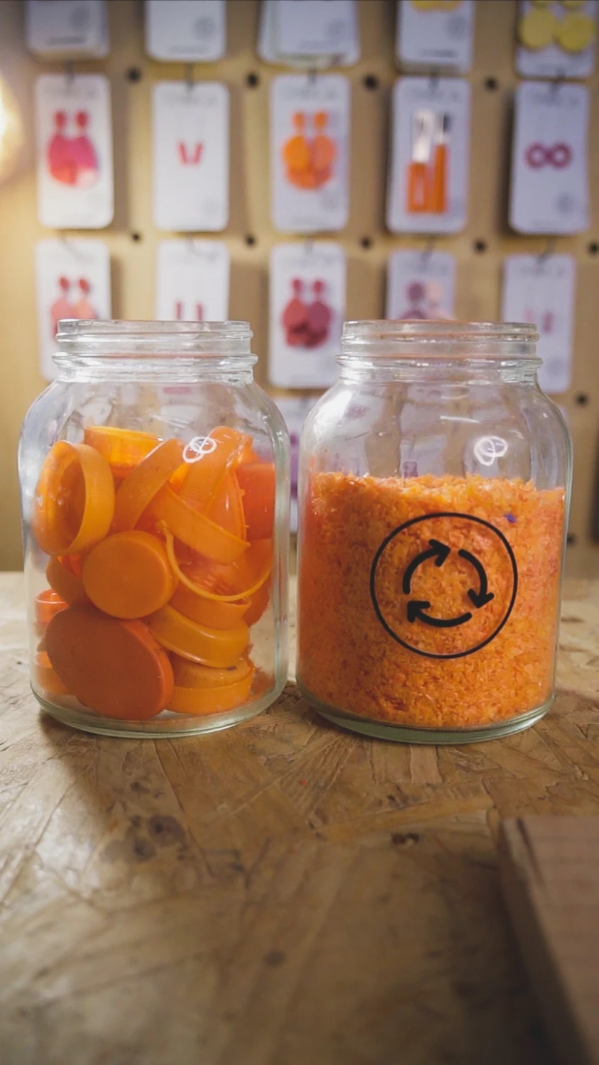 Frascos naranjas con tapas y material reciclado en el universo visual de ONÍRICA